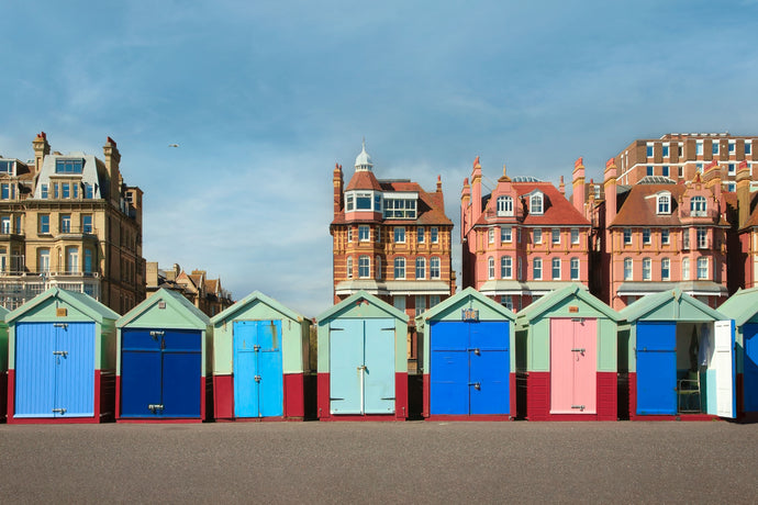 color photo of beach huts and victorian homes in brighton england