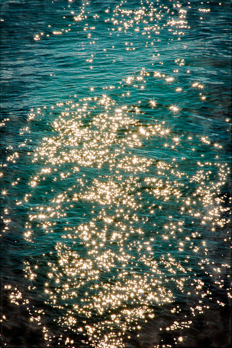 fine art mixed media image of golden stars sparkling in saturated blue sea