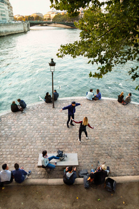 People enjoy the late afternoon sun in paris with dancing, music and wine