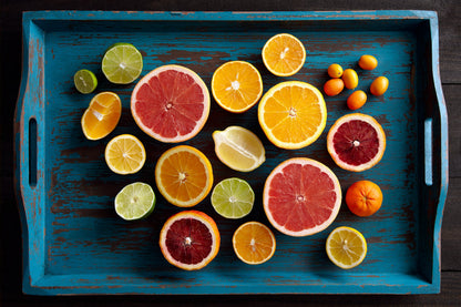 fine art color still life of sliced citrus, oranges and lemons on a rustic blue tray