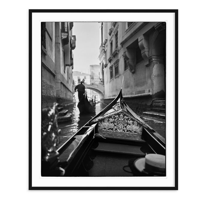 black and white fine art image from inside a gondola in a canal in venice, italy