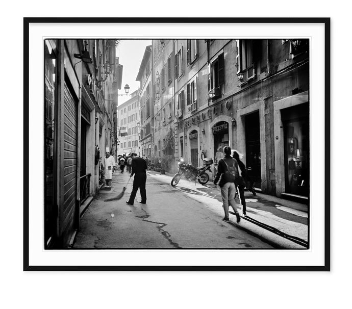 black & white travel photo of people on beautiful street in rome with late afternoon sun